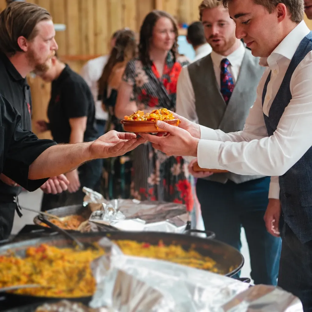 Our team serving live-cooked paella to guests at an event